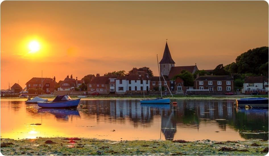 A sunset photograph over a docks and small village.