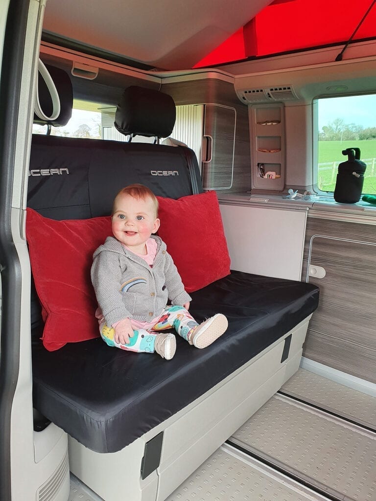 A photo of a baby enjoying their time in a VW campervan seat.